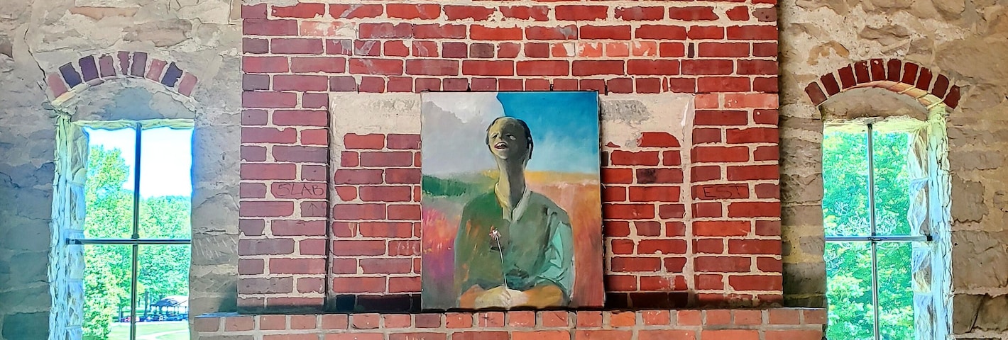 A brick fireplace with two arched windows and a painting above it.