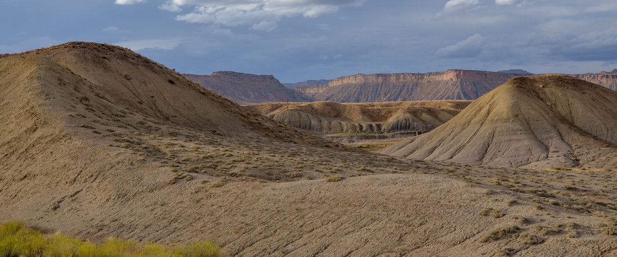 A desert landscape with rolling hills and a clear sky.