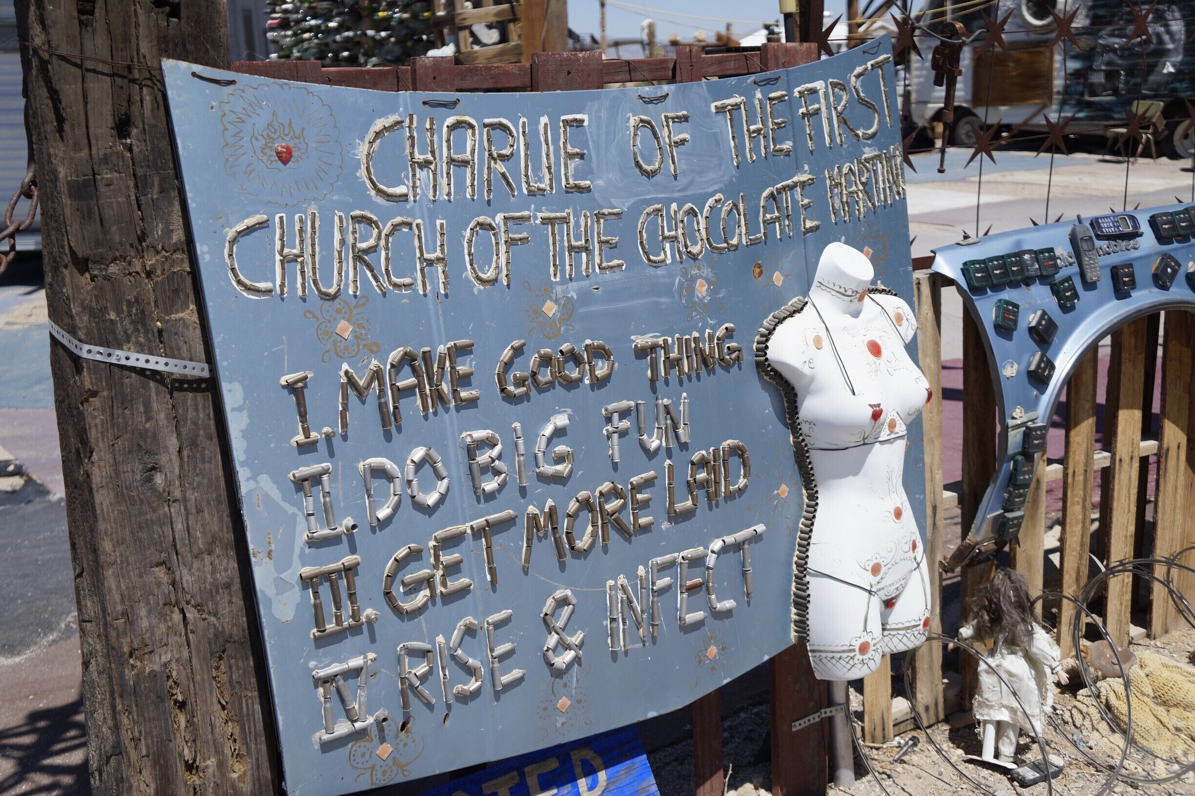 A sign with a mannequin and a collection of mobile phones.