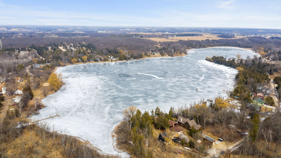 A frozen river with houses and trees along its banks.