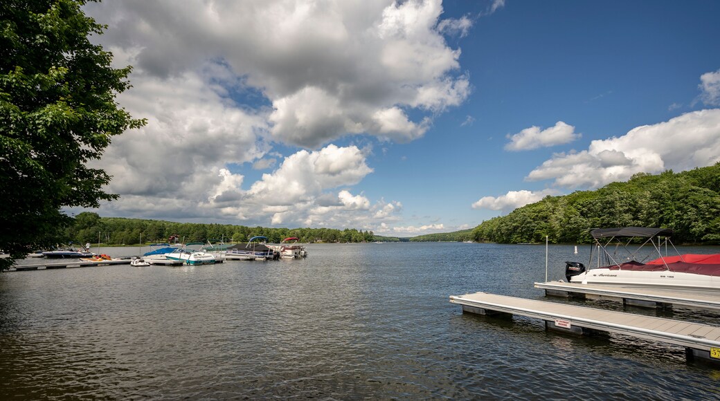 Sun shines on a tranquil dock while boats rock silently in the rippling water of Deep Creek Lake in rural Garrett County, Maryland, USA.