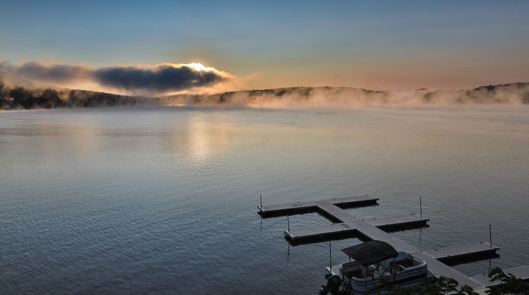Dramatic sunrise over Deep Creek Lake with an empty dock. Maryland, USA.