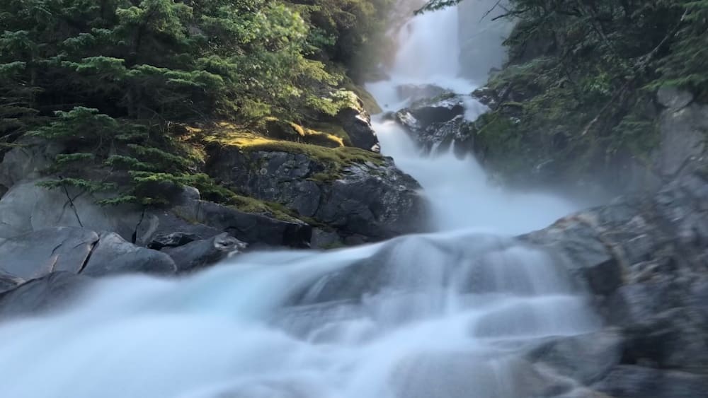 A waterfall cascading over rocks in a forested area.