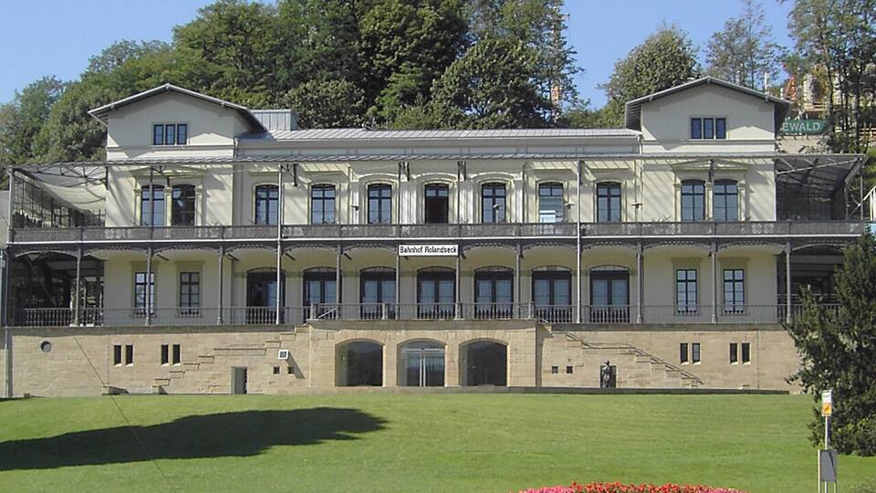 A large, historic building with a symmetrical facade, multiple windows, and a central entrance.