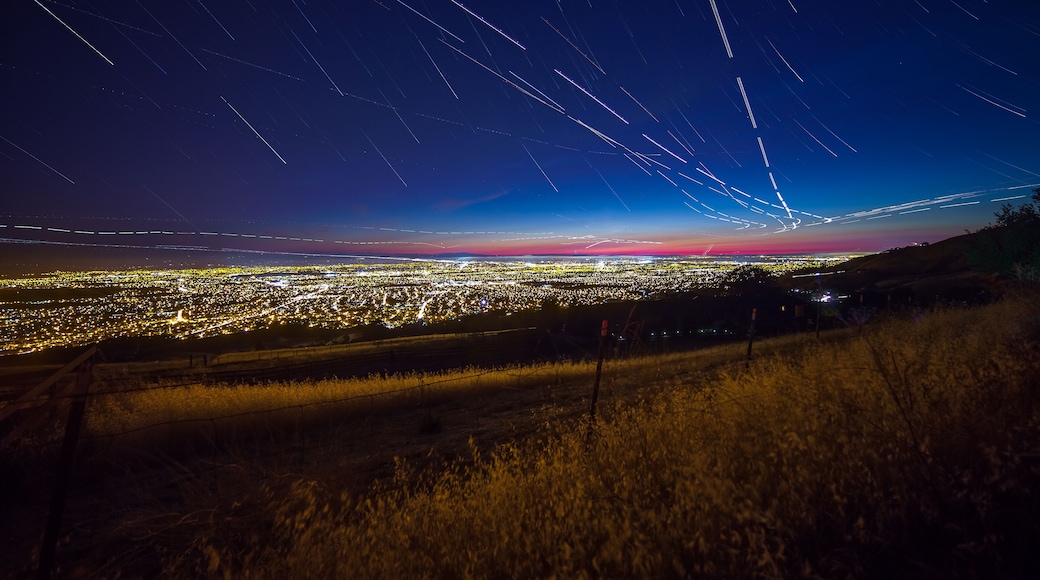 View of the Silicon Valley from Mount Hamilton at night with stars and plane trails.