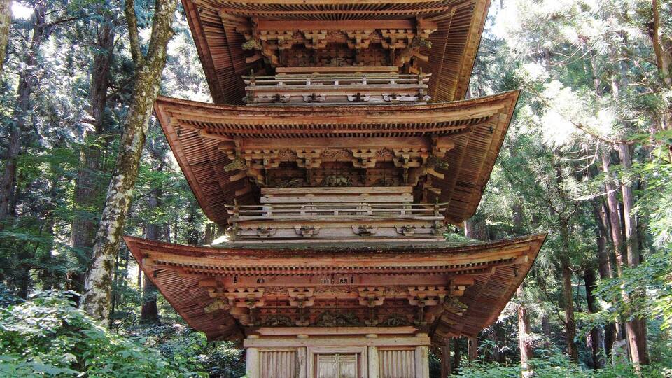 A traditional multi-tiered pagoda in a forested area.