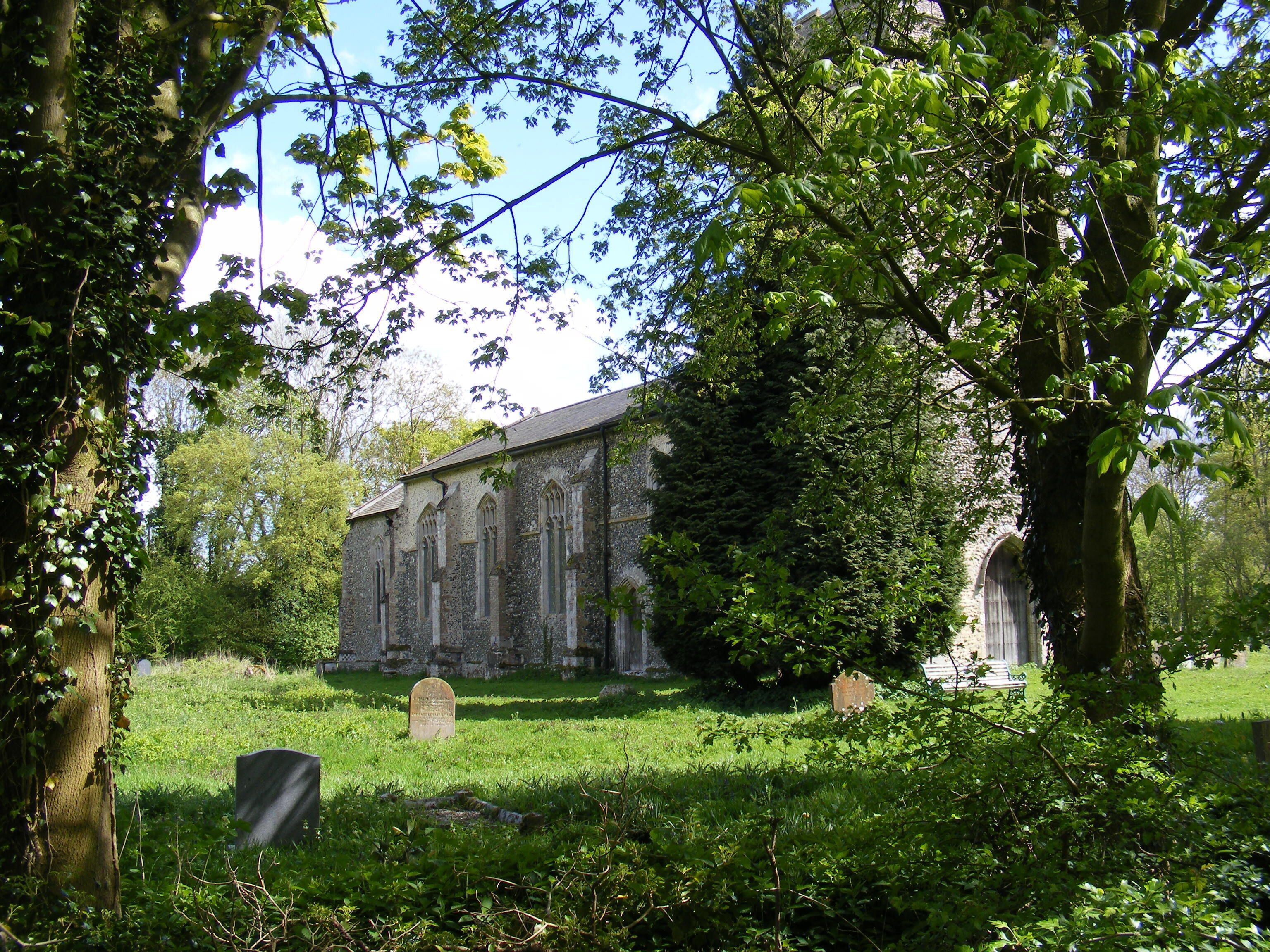 A church surrounded by lush greenery and trees.