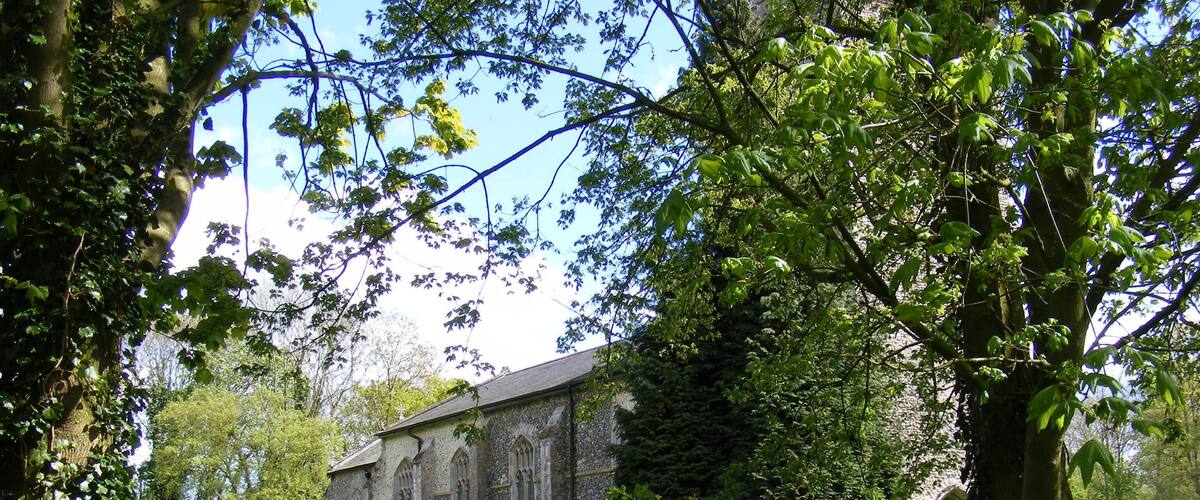 A church surrounded by lush greenery and trees.