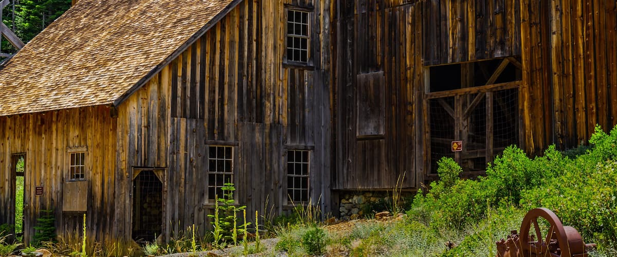An old wooden barn with a slanted roof and a metal door.