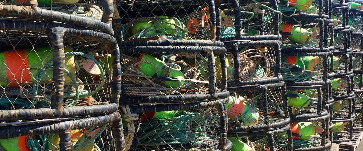 A series of stacked lobster traps along a road.