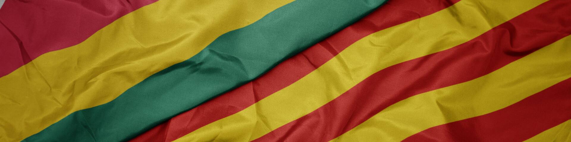 waving colorful flag of catalonia and national flag of togo.
