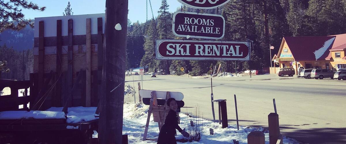 A sign for Strawberry Lodge with rooms available and ski rental.