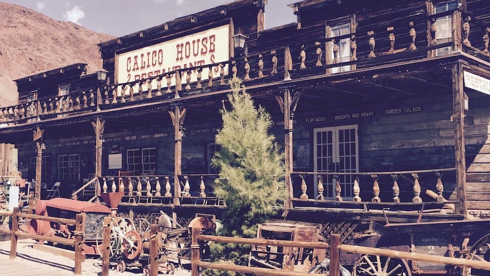 A rustic building labeled "Calico House Restaurant" with wooden architecture and a signboard.