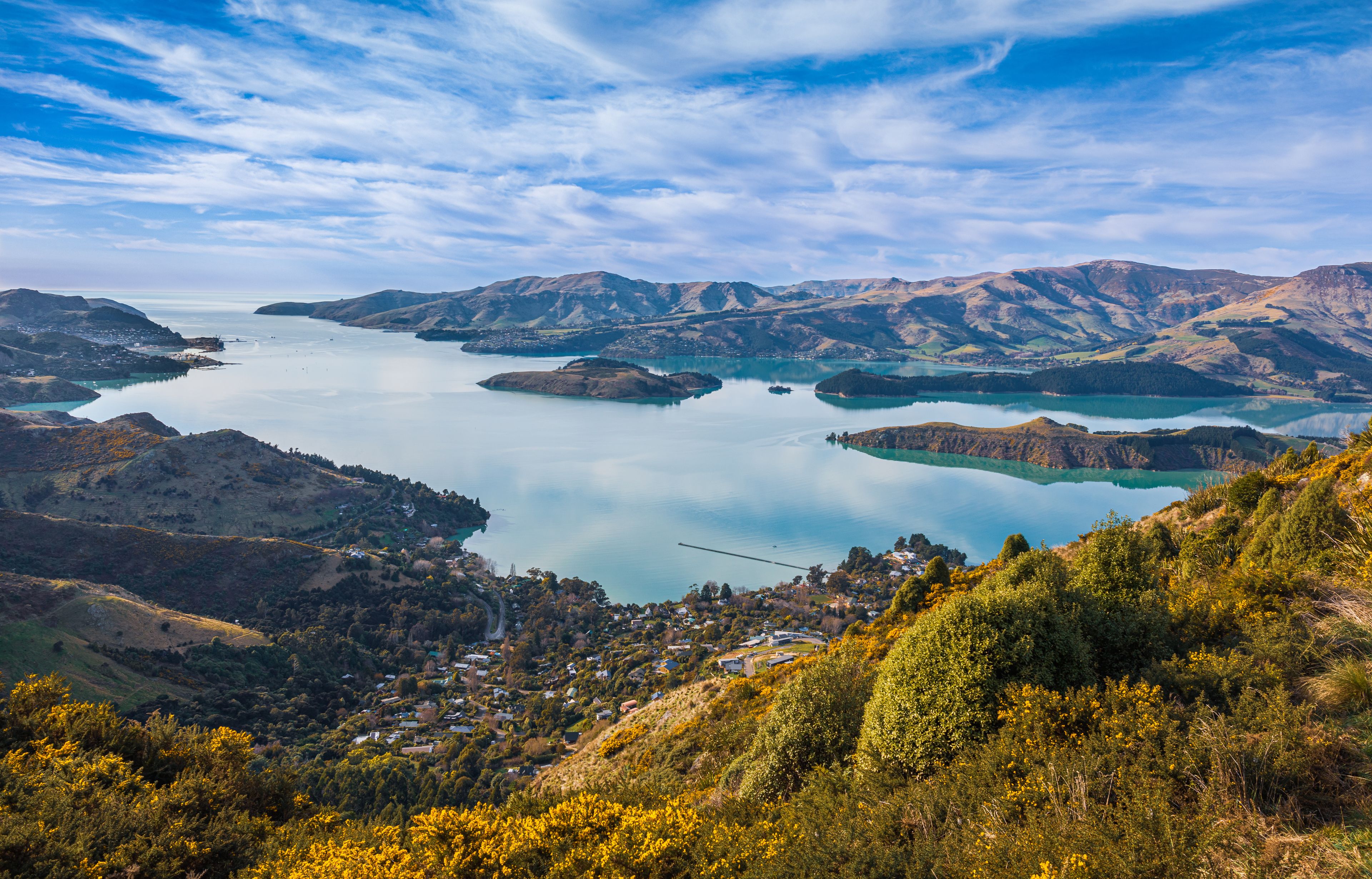 A mountainous landscape with a large lake surrounded by hills and a small town.