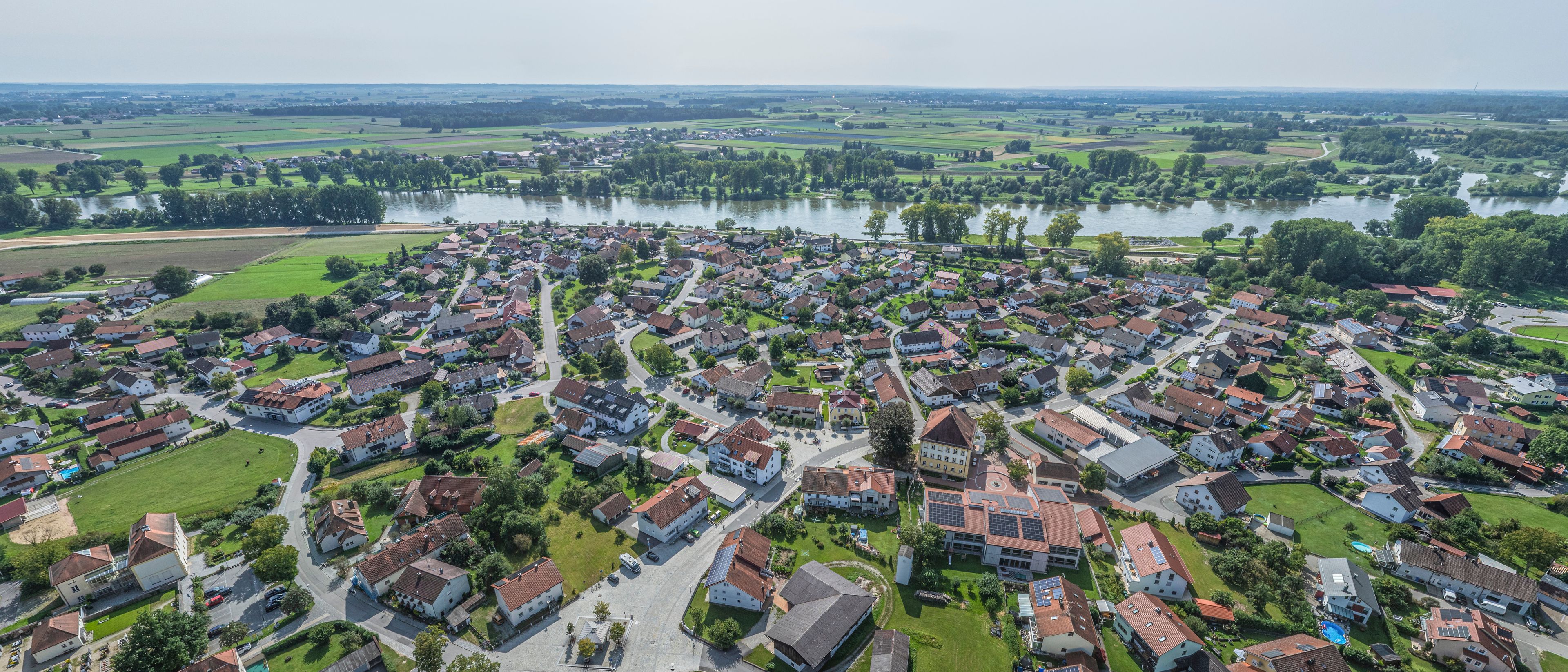 A residential area with houses, roads, and a river.