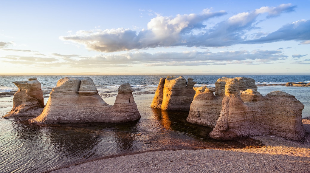 Un paysage côtier avec des formations rocheuses et l’océan.