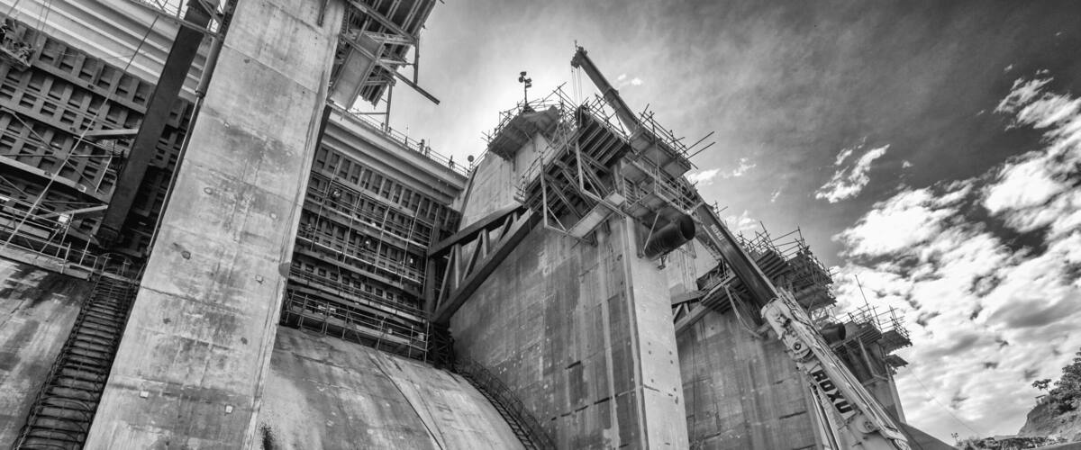 A large industrial structure with scaffolding and a crane, likely a construction site.
