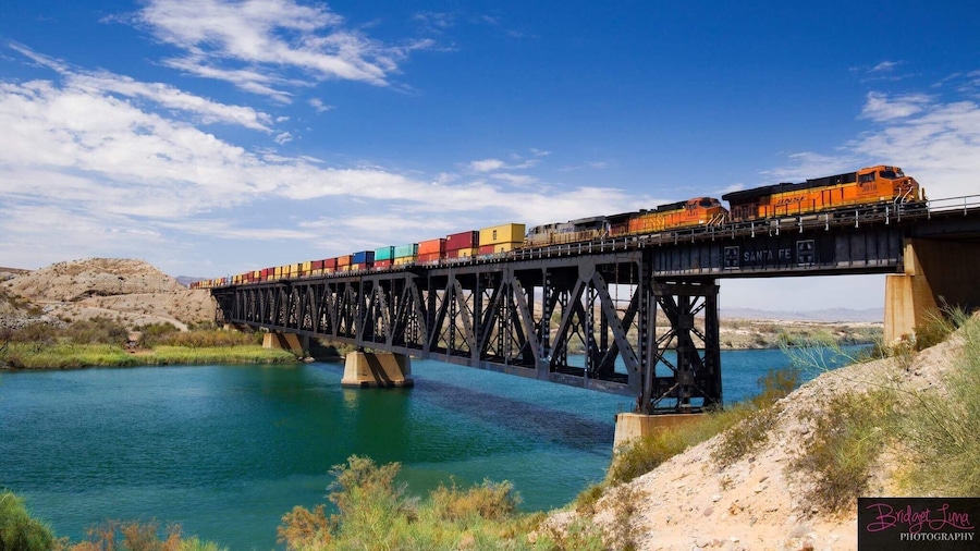 A train on a bridge over a river.