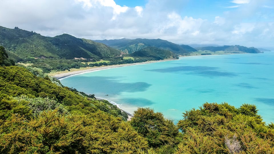 Stunning aerial drone view of the coastline at Whituare Bay near Opotiki and Whakatane in the eastern part of New Zealand. Beautiful color of the water and green mountains.