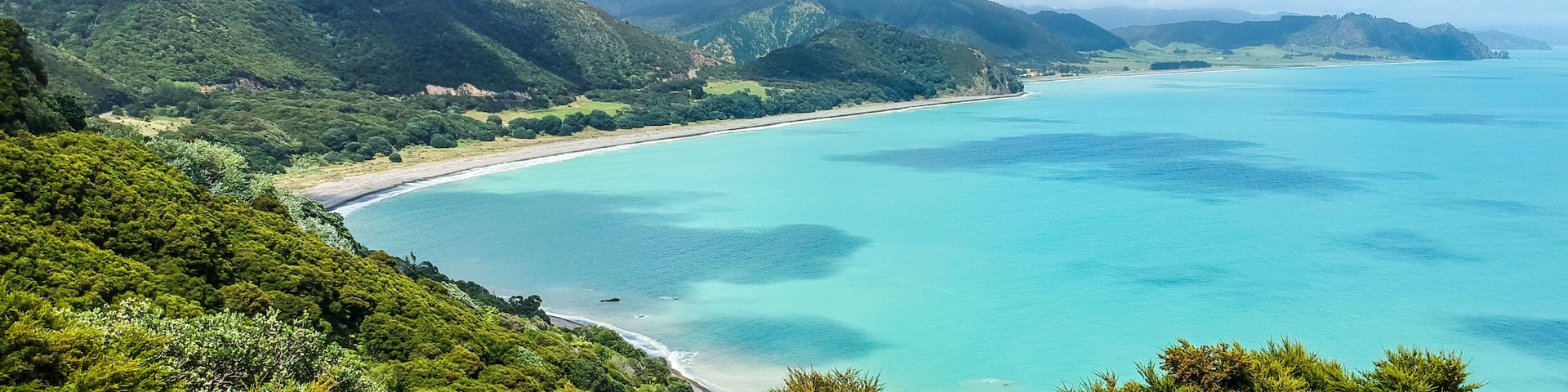 Stunning aerial drone view of the coastline at Whituare Bay near Opotiki and Whakatane in the eastern part of New Zealand. Beautiful color of the water and green mountains.