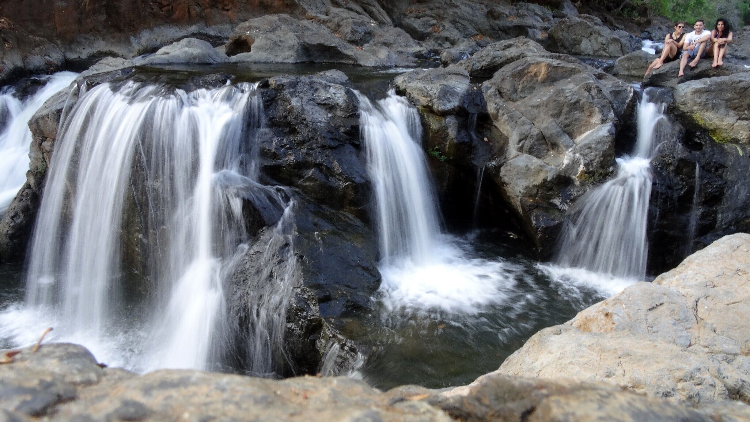 A waterfall cascading over rocks in a natural setting.