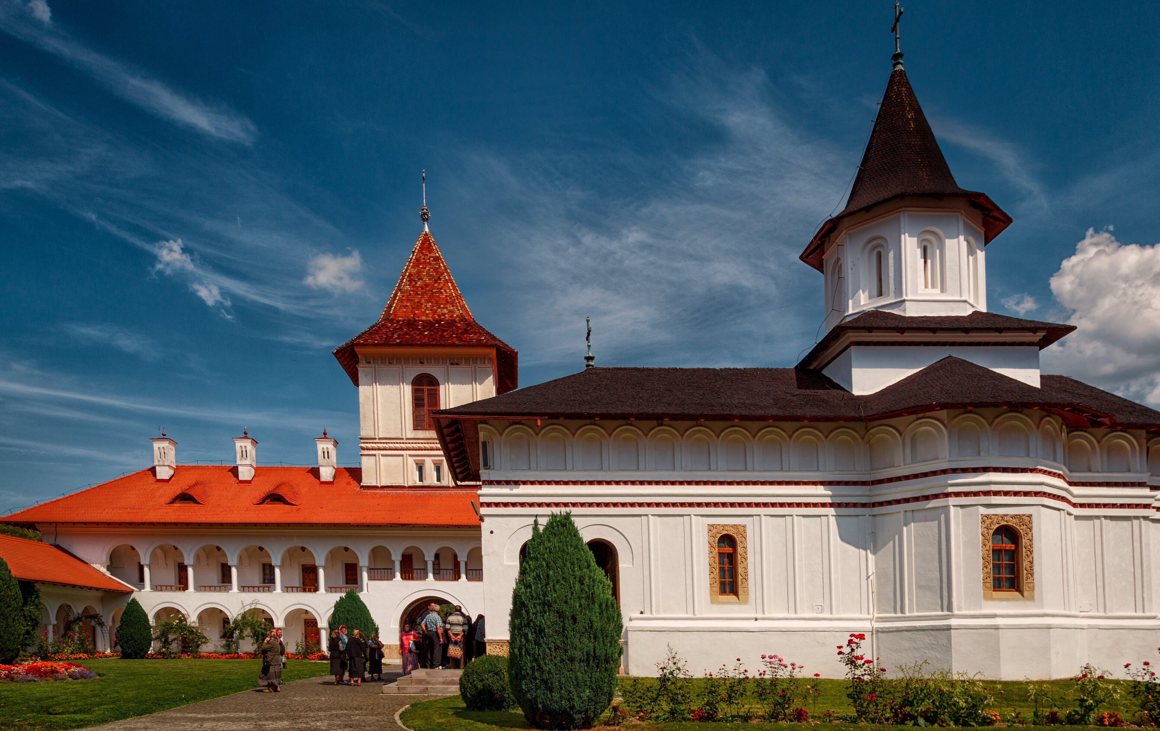 A white church with a red roof and a tall tower.