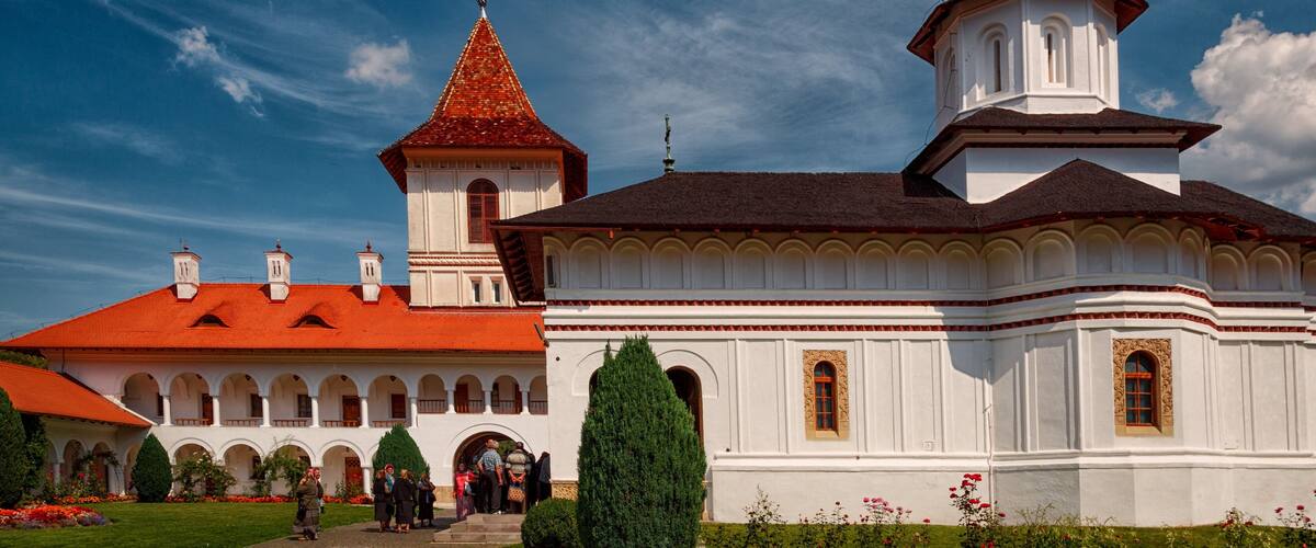 A white church with a red roof and a tall tower.