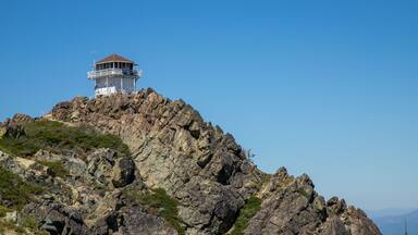 A rocky mountain with a lighthouse on top.