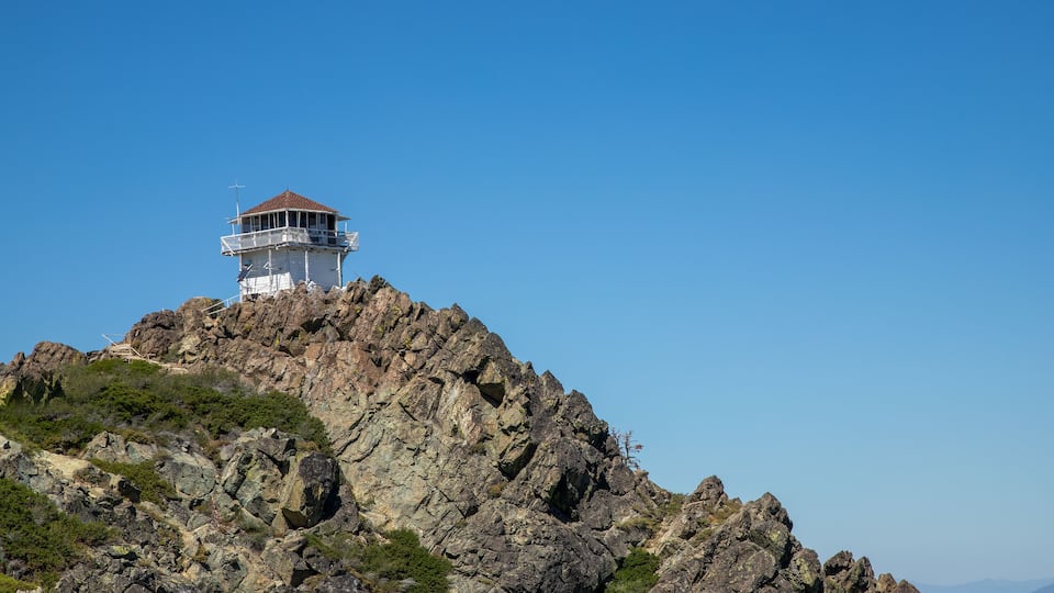 A rocky mountain with a lighthouse on top.