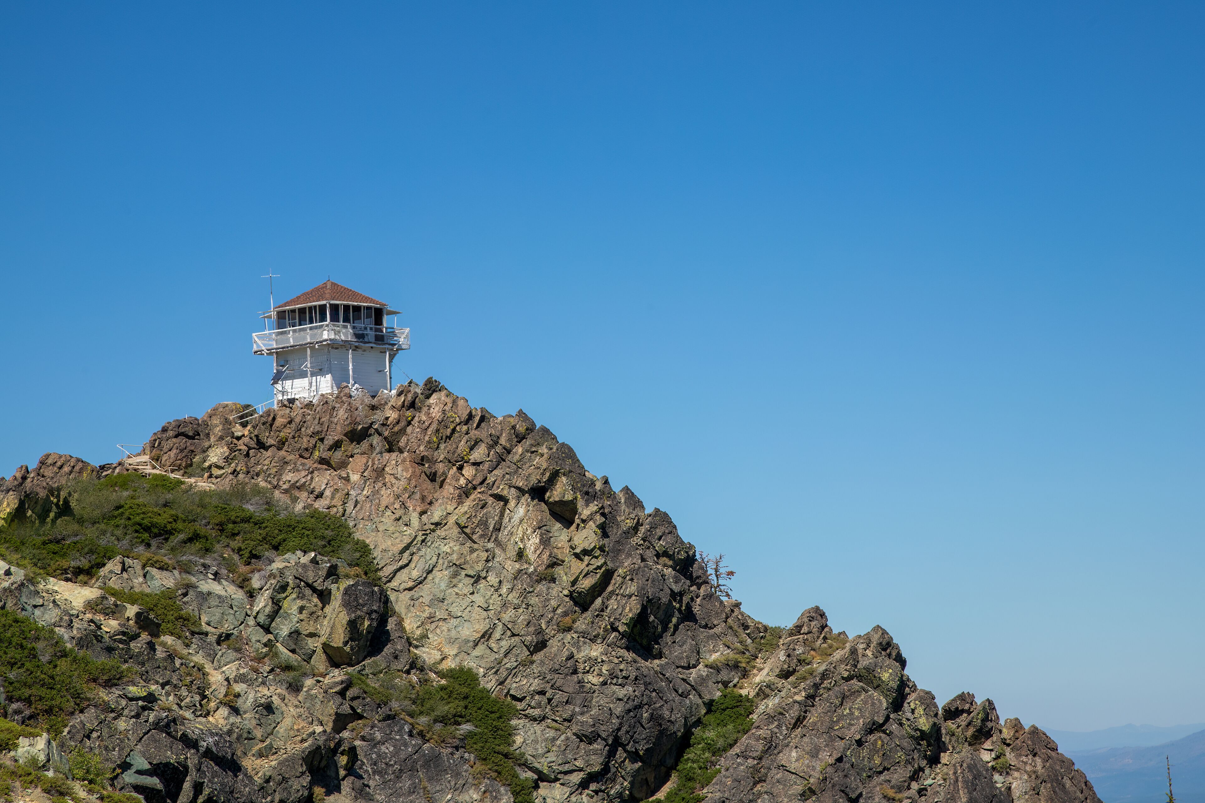 A rocky mountain with a lighthouse on top.