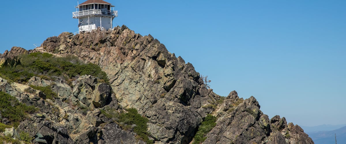 A rocky mountain with a lighthouse on top.