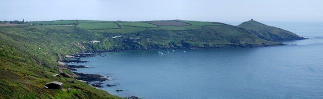 Rame peninsula. This panoramic shot of the Rame peninsula takes in its sweep from Rame Church (far left at SX426491) to the chapel on Rame Head (the little square, far right at SX418483 ). Between these but nearer the latter can just be made out the mast of the Coast Guard station (at SX420487). Nearer sea-level the buildings clustered towards the left are at Polhawn, with Polhawn Fort, dating from Napoleonic times, the rightmost of these. A clutch of boats can be seen dotting the sea near the coves (Polhawn, Crane and Long) of this coast. The photo was taken from the coast road - also known as the Military Road - that runs along the top of the cliffs above Whitsand Bay. The actual spot it was taken from is directly above 529712 which lie on the sands due south west, and about 350' (100m) below.