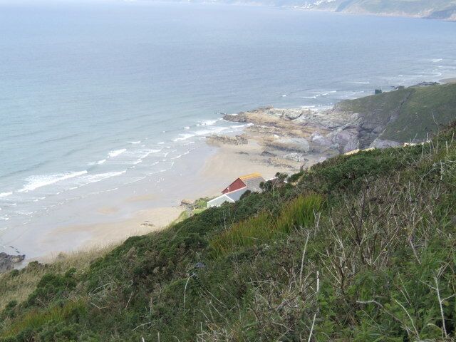 Freathy Cliff - view westwards The roof of a holiday home halfway down the slope can just be seen, with the rocks of Sharrow point beyond.