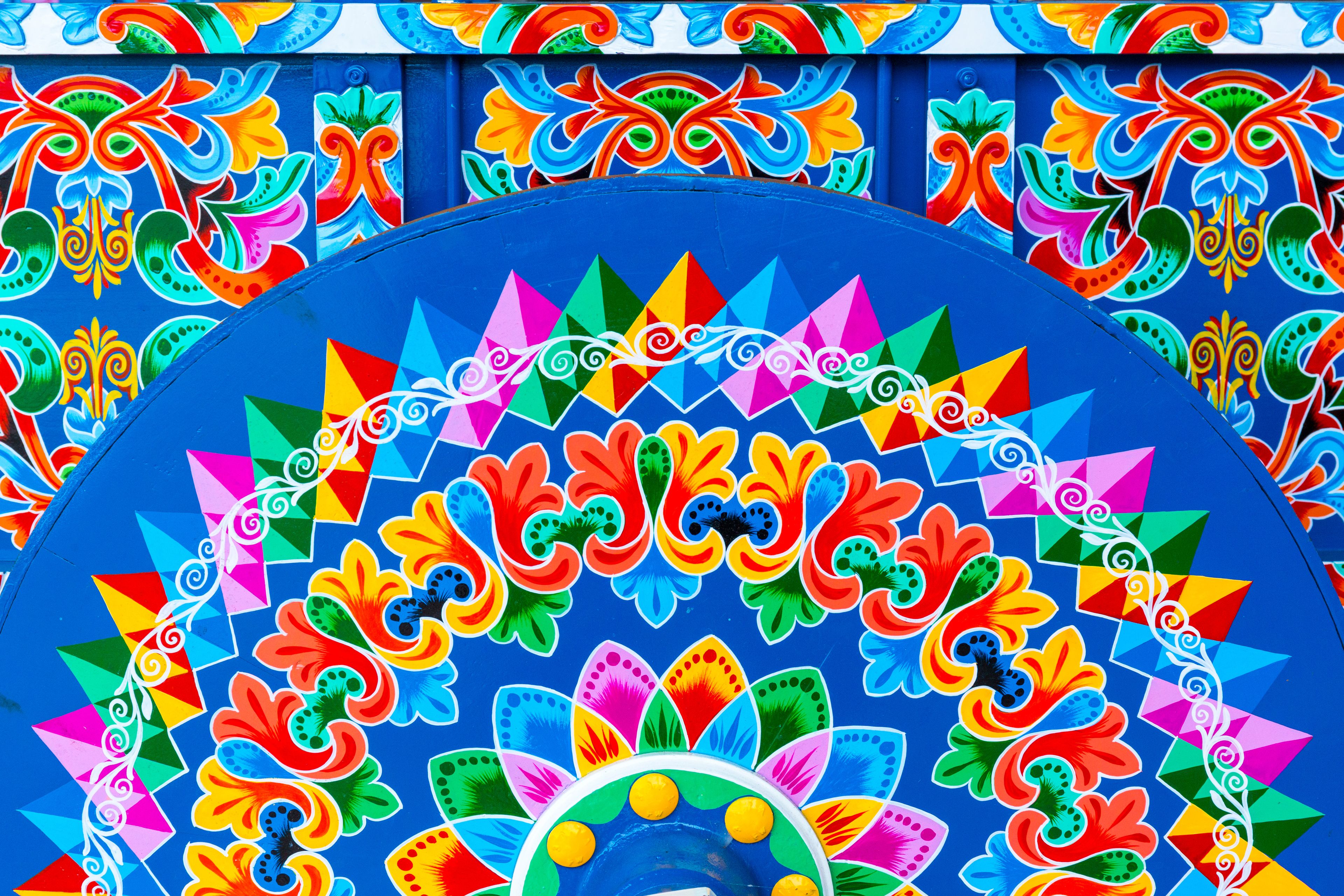 A vibrant, colorful mural with geometric patterns and floral designs.