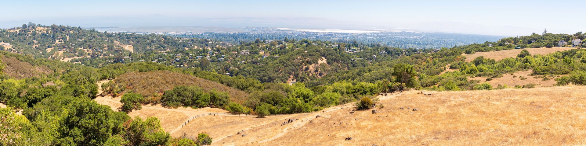 Panorama. Rural summer landscape with a road, field and forest. Hot summer day, blue sky. Rural path. Panoramic view. View from above. California, Edgewood Park
