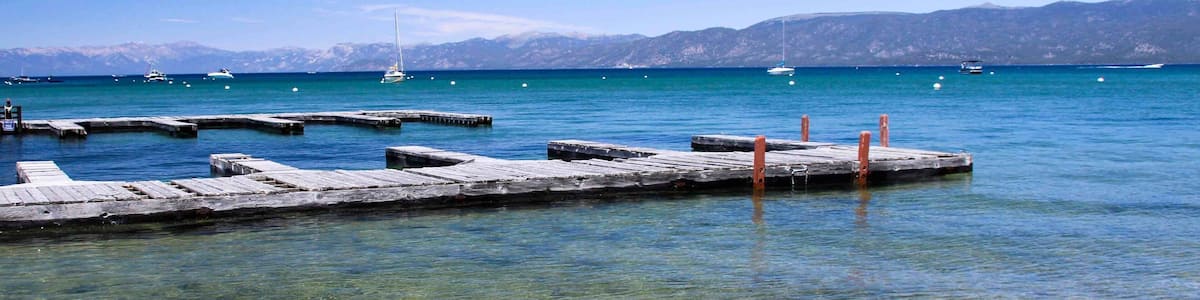 Une vue dégagée sur la côte, avec des jetées en bois et des bateaux sur l’eau.