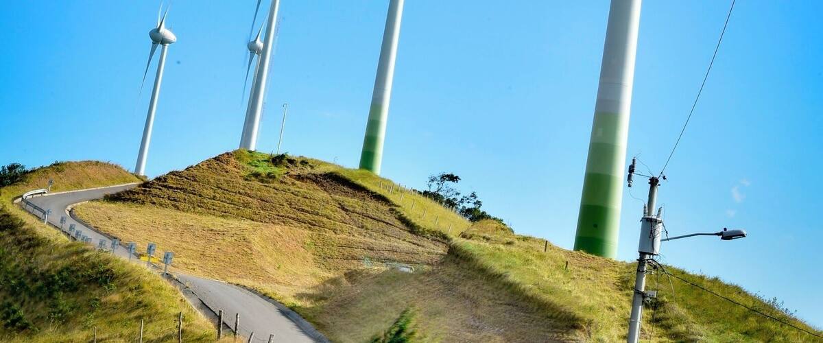 Wind turbines on a hill with a winding road.