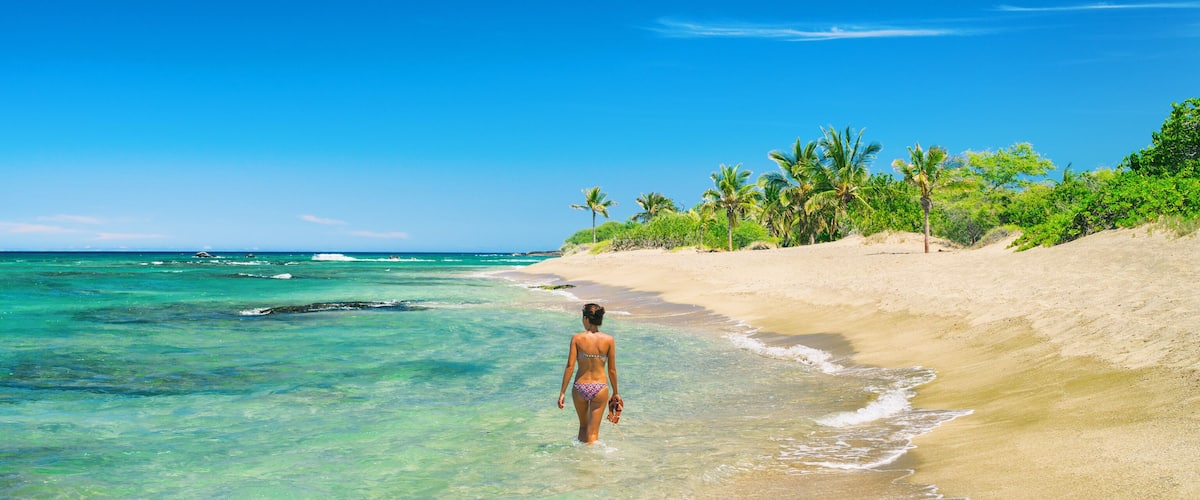 Hawaii beach woman relaxing swimming in bikini in idyllic ocean of lost paradise remote island tropical getaway. Wanderlust and adventure lifestyle banner panorama.