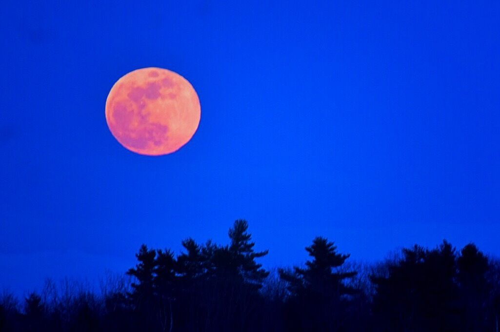 A full moon rises as viewed from Kent’s Hill