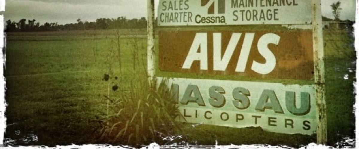 A signboard with Princeton Airport, AVIS, and MASSAU Helicopters.