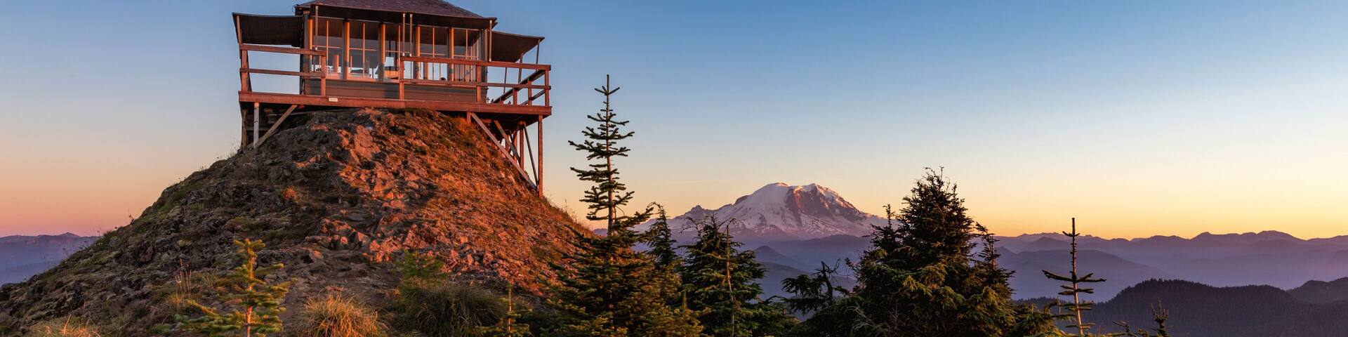 Panoramic view of a fire lookout with mt rainier in the background during the sunset