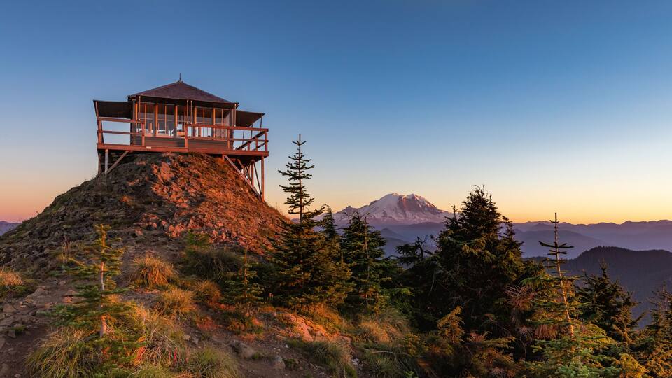 Panoramic view of a fire lookout with mt rainier in the background during the sunset