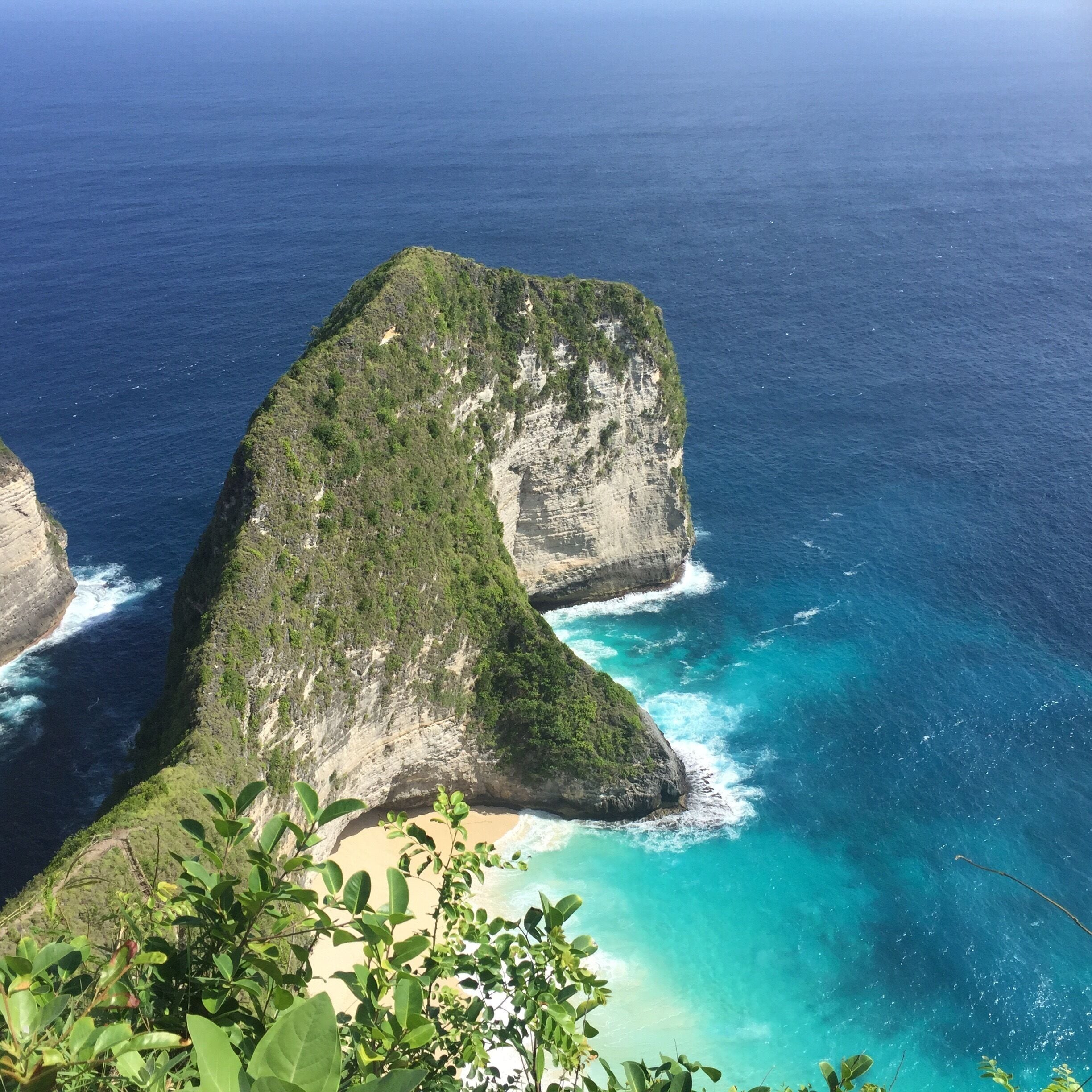 A coastal cliff with a turquoise sea.
