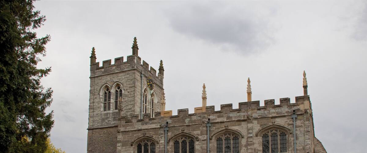 A historic stone church with a tall tower and arched windows.