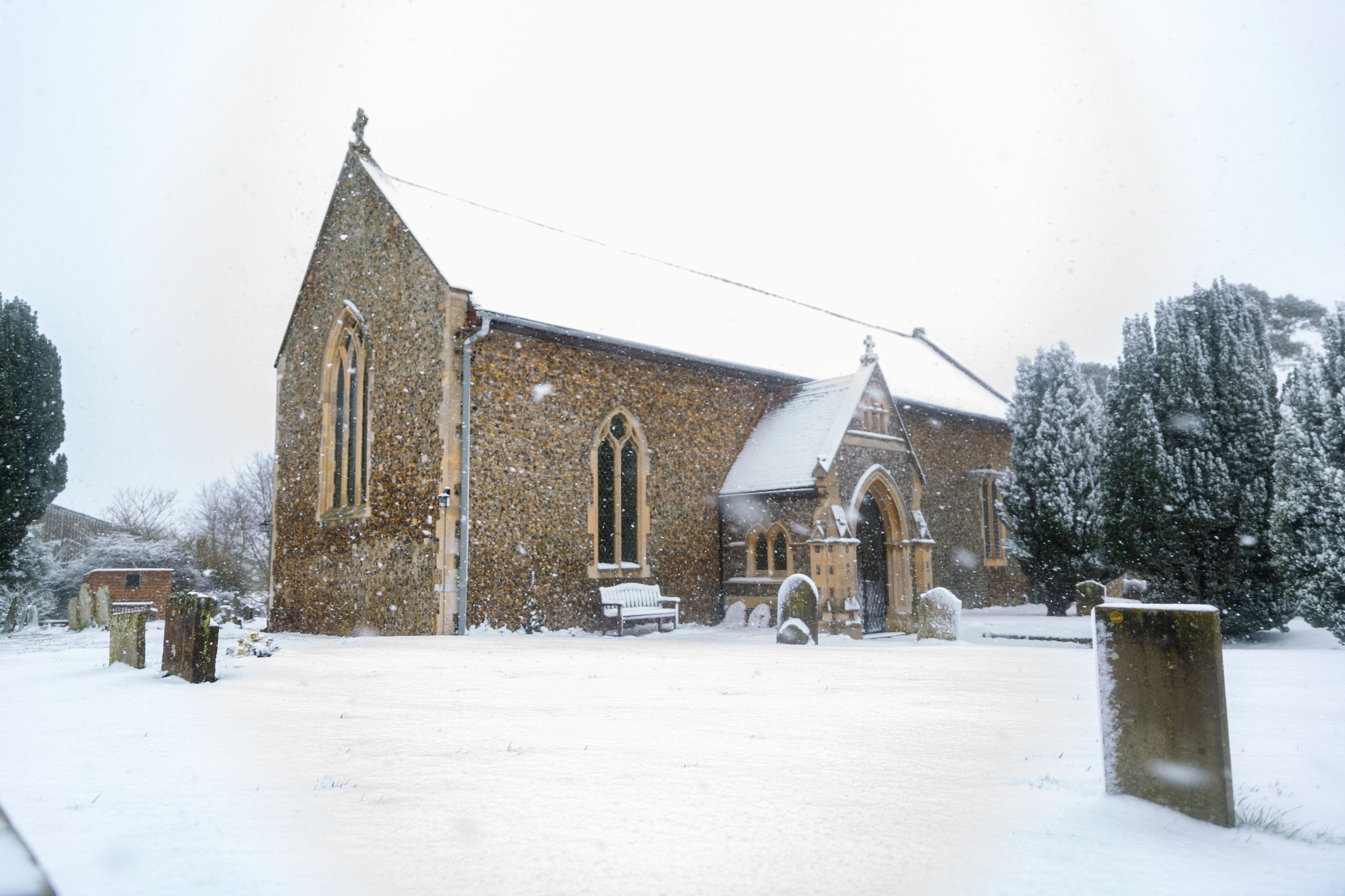 A church with a steeple and a snow-covered roof.