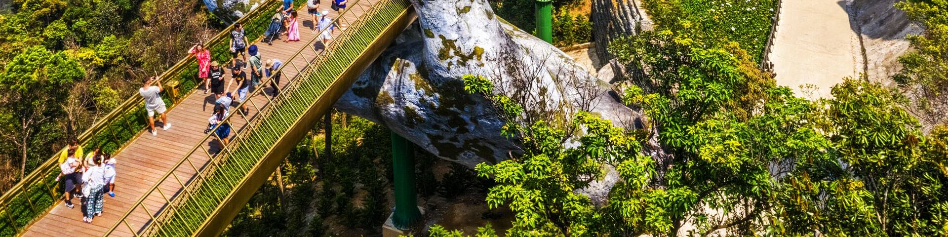 Top aerial view of the famous Golden Bridge is lifted by two giant hands in the tourist resort on Ba Na Hill in Da Nang, Vietnam. Cau Vang is a favorite destination for tourists , Shutterstock ID 13