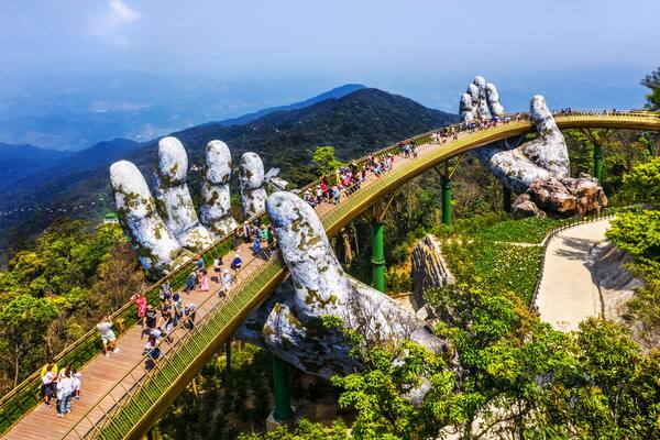 Top aerial view of the famous Golden Bridge is lifted by two giant hands in the tourist resort on Ba Na Hill in Da Nang, Vietnam. Cau Vang is a favorite destination for tourists , Shutterstock ID 13