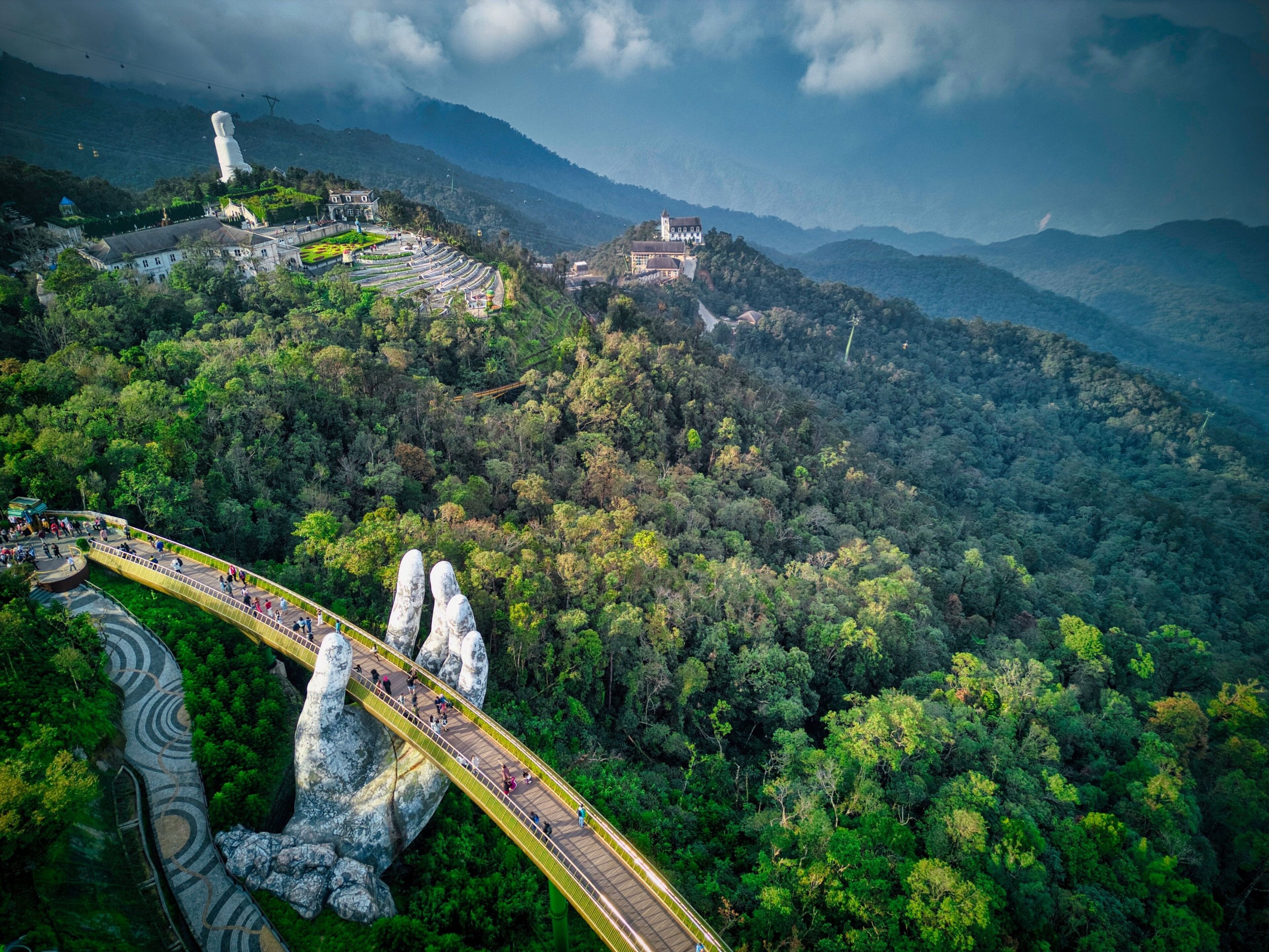 Aerial shot of the Golden bridge spanning a lush green valley in Vietnam.