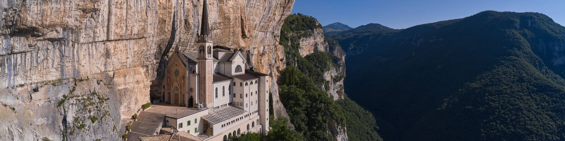 Church in the rock, Santuario della Madonna della Corona. An old church, built around 1625, on a quiet, picturesque mountainside. Madonna della Corona Sanctuary aerial view, surrounded by mountains.