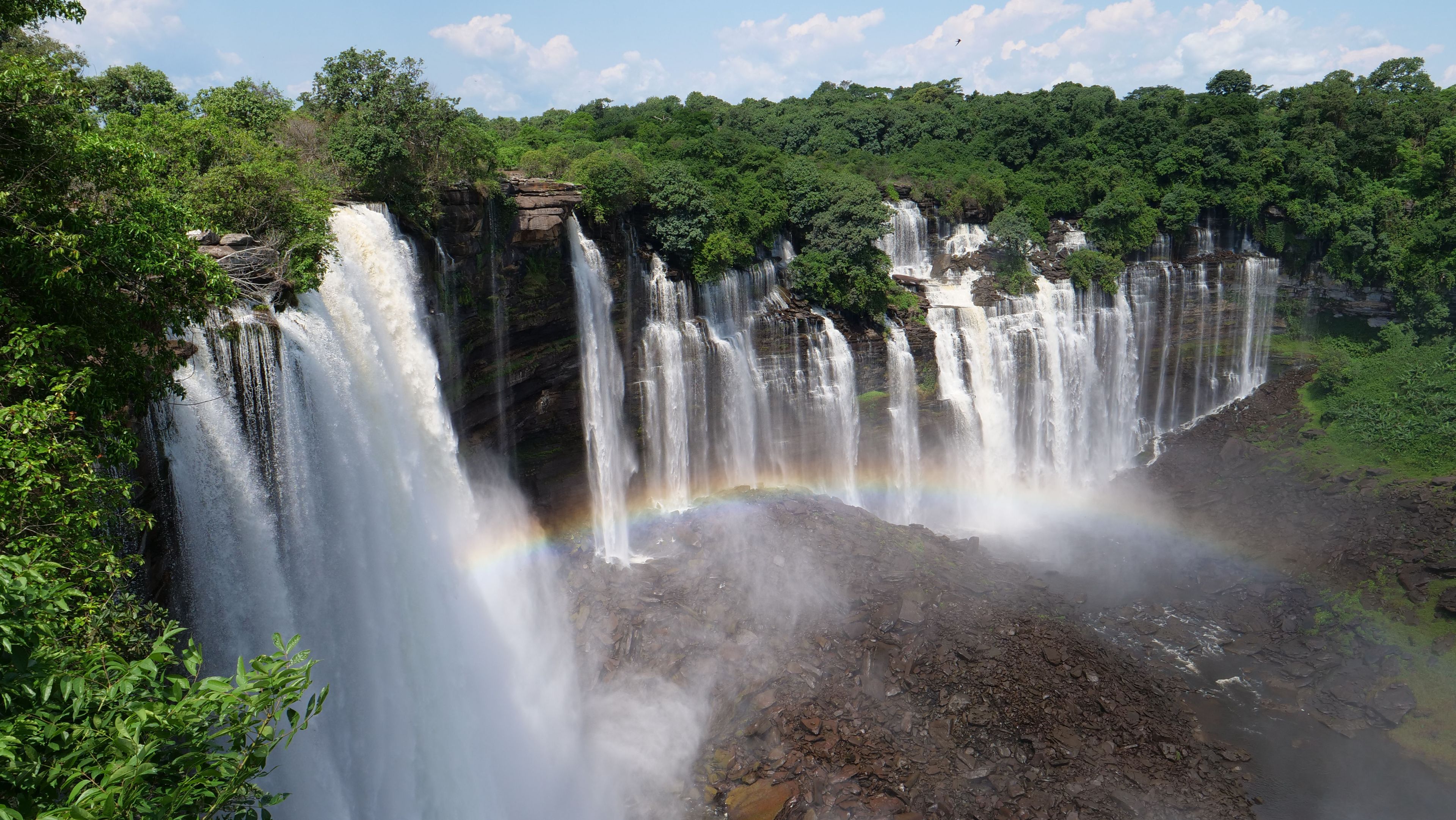 Ein mehrstufiger Wasserfall, umgeben von dichtem Grün.